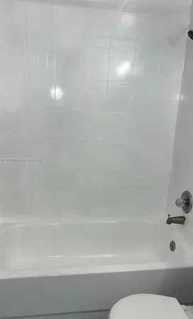 a bathroom with a granite countertop bathtub sink vanity and toilet
