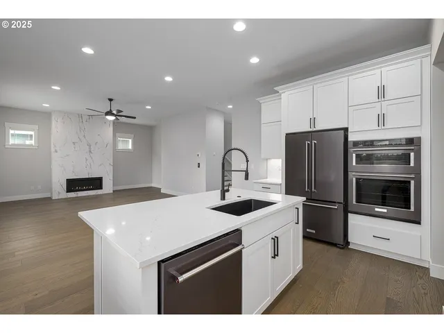 a kitchen that has a sink a microwave a stove and refrigerator