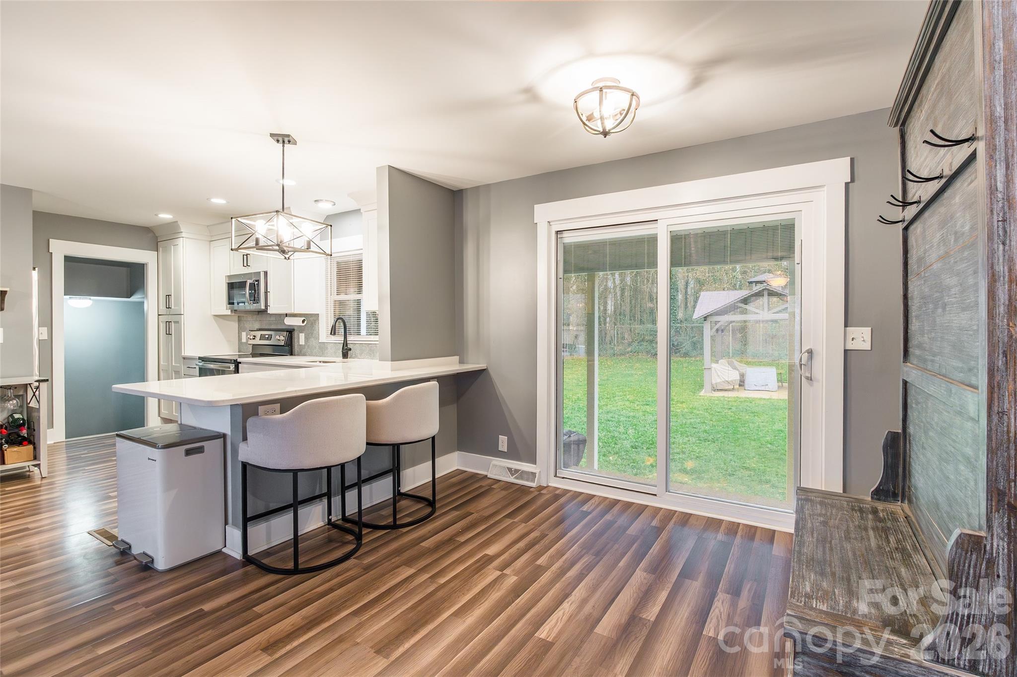 245 Mellon Road Belmont, NC 28012 - Photo 6 of 30 a dining room with wooden floor a chandelier a glass table and chairs