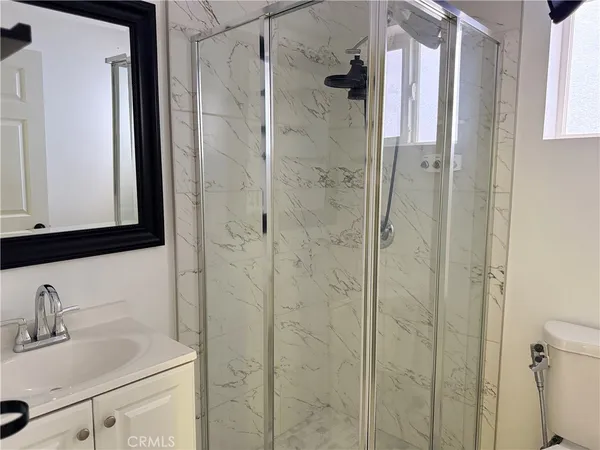 a bathroom with a sink vanity granite and shower