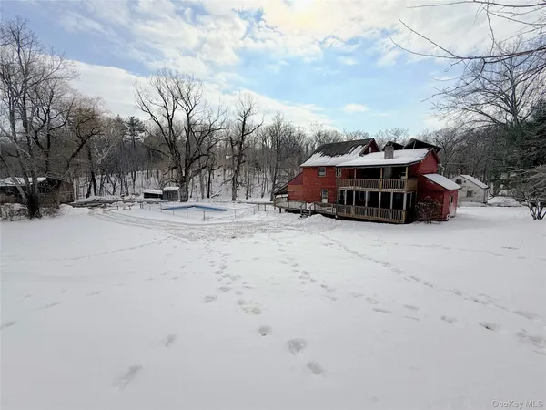 a view of large house with a yard covered in snow