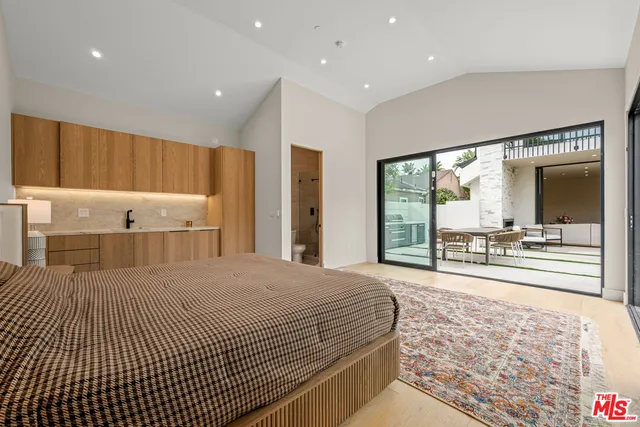 a bed sitting in a spacious bedroom next to a window