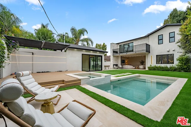 a kitchen with stainless steel appliances kitchen island granite countertop a table and chairs in it
