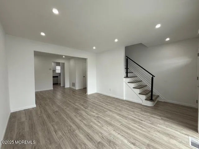 a view of entryway and hall with wooden floor