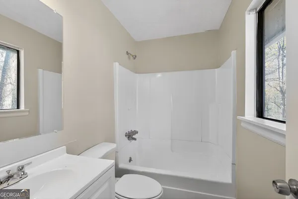 a white toilet sitting next to a bathroom sink