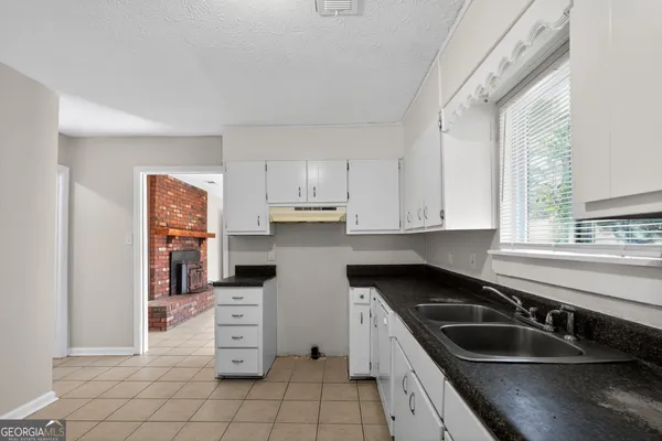 a kitchen filled with white cabinets and sink