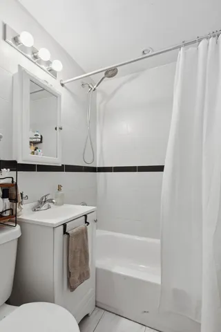 a bedroom with a bed a large window with table and chairs