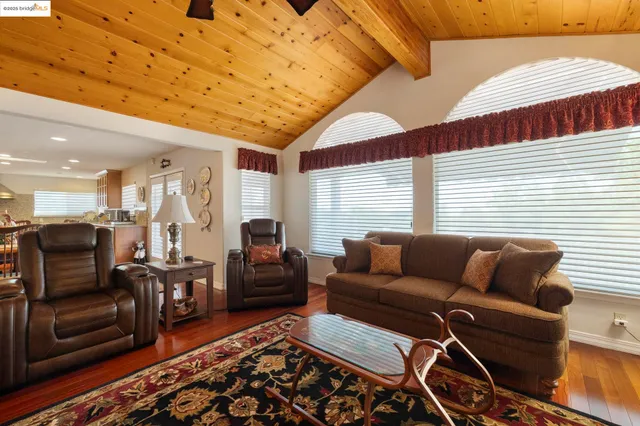 a living room with furniture a wooden floor and next to a window