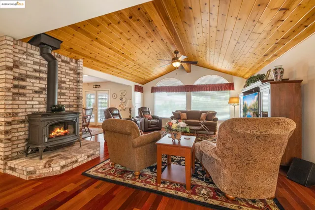 a living room with furniture a fireplace and a floor to ceiling window