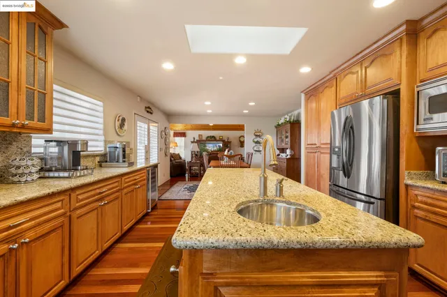 a kitchen with stainless steel appliances granite countertop a sink and a refrigerator