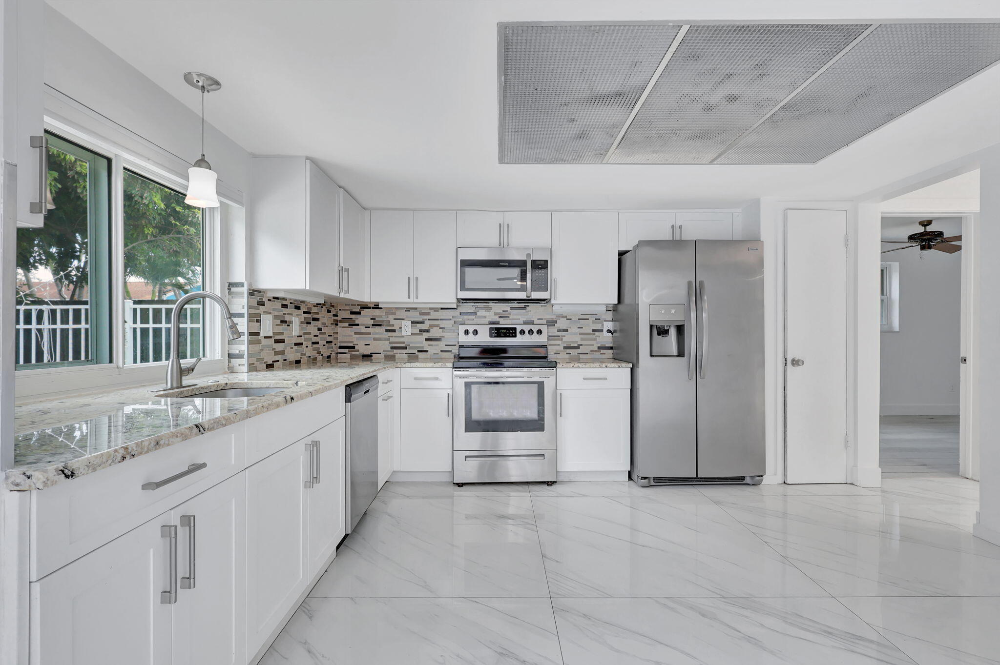 334 Southwest 13th Avenue Boynton Beach, FL 33435 - Photo 13 of 41 a kitchen with granite countertop white cabinets and stainless steel appliances