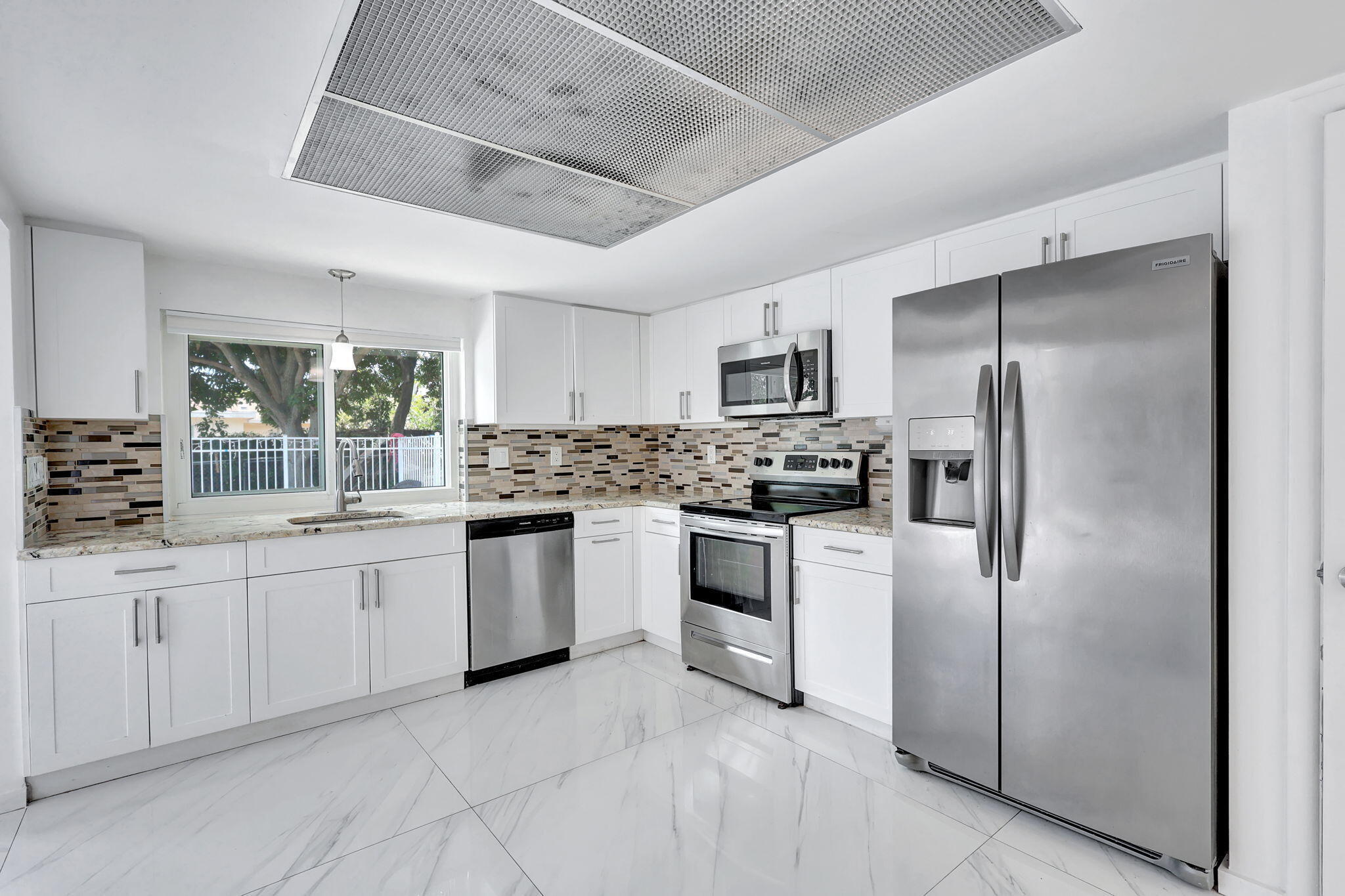 334 Southwest 13th Avenue Boynton Beach, FL 33435 - Photo 15 of 41 a kitchen with white cabinets stainless steel appliances and a window