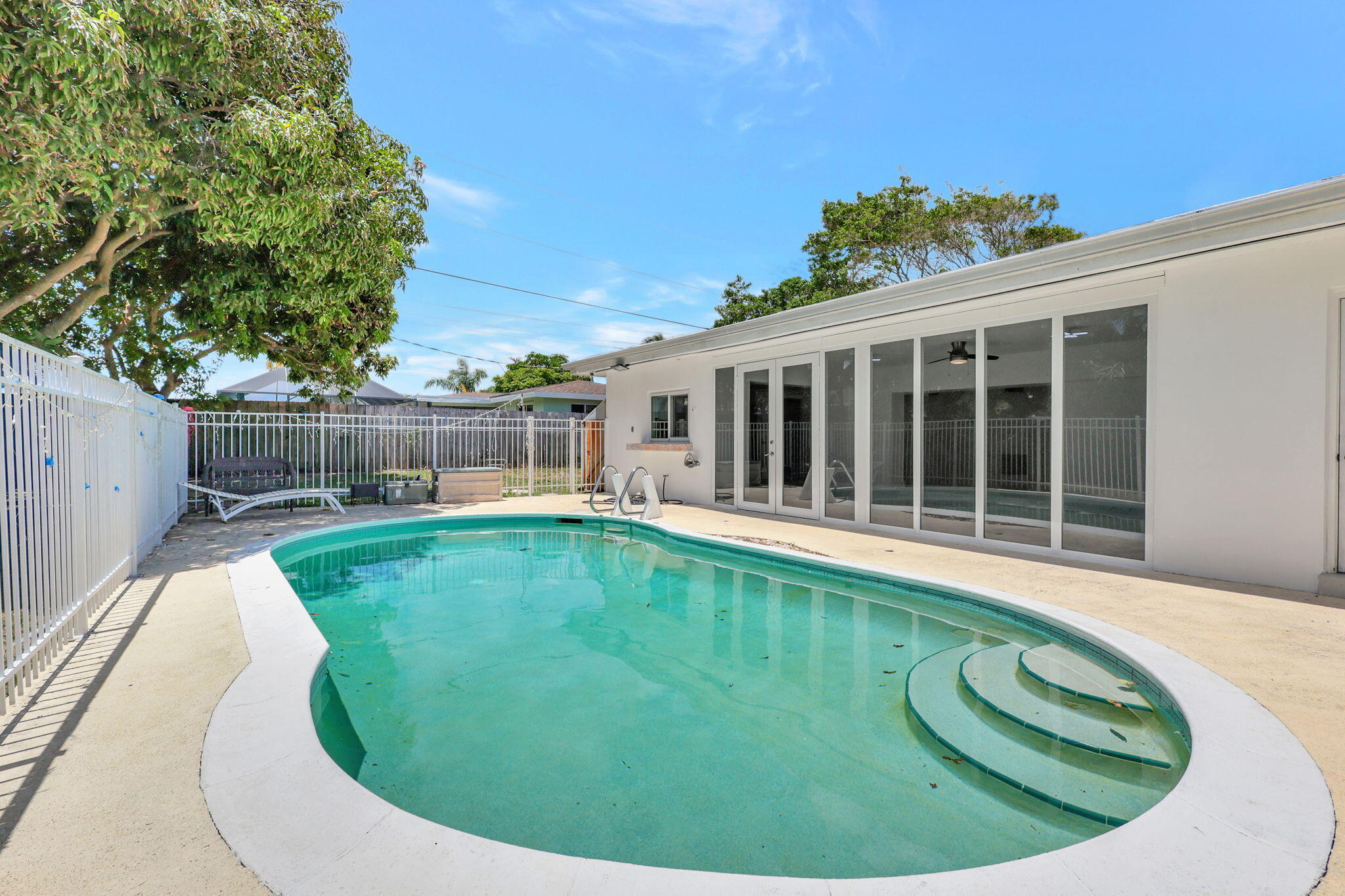 334 Southwest 13th Avenue Boynton Beach, FL 33435 - Photo 2 of 41 a swimming pool with outdoor seating and garden