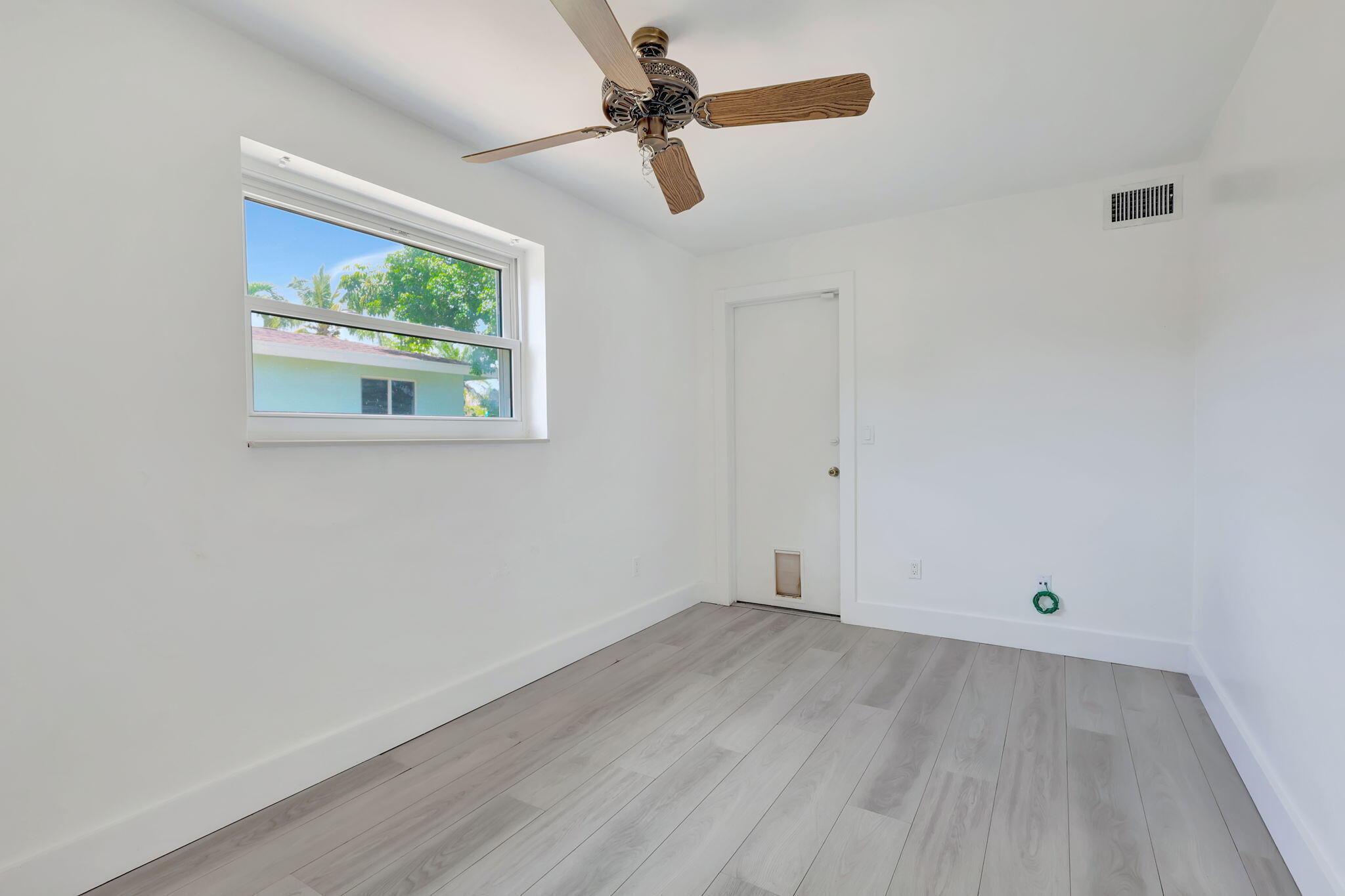 334 Southwest 13th Avenue Boynton Beach, FL 33435 - Photo 30 of 41 an empty room with wooden floor ceiling fan and windows