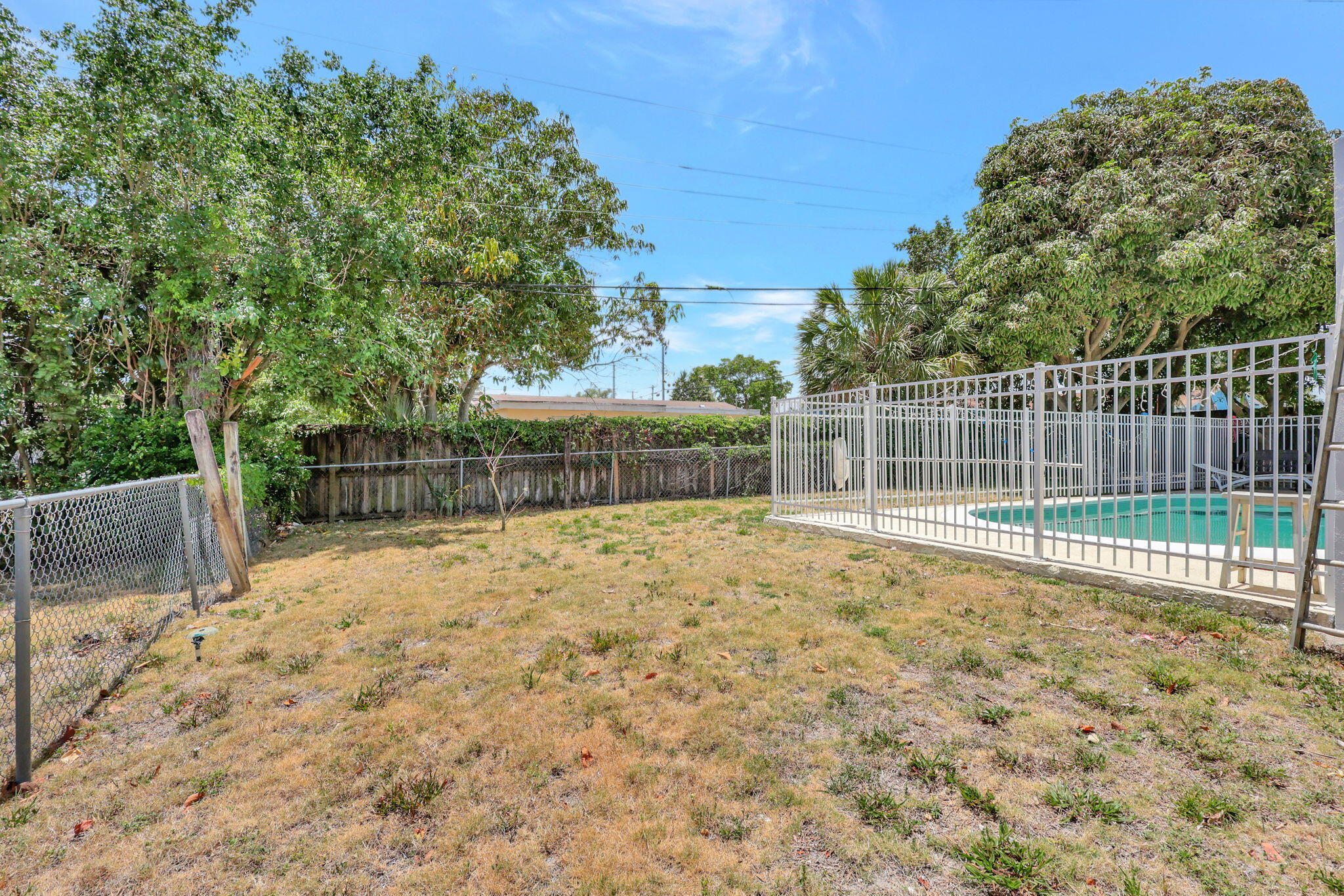 334 Southwest 13th Avenue Boynton Beach, FL 33435 - Photo 38 of 41 a view of backyard with wooden fence and trees