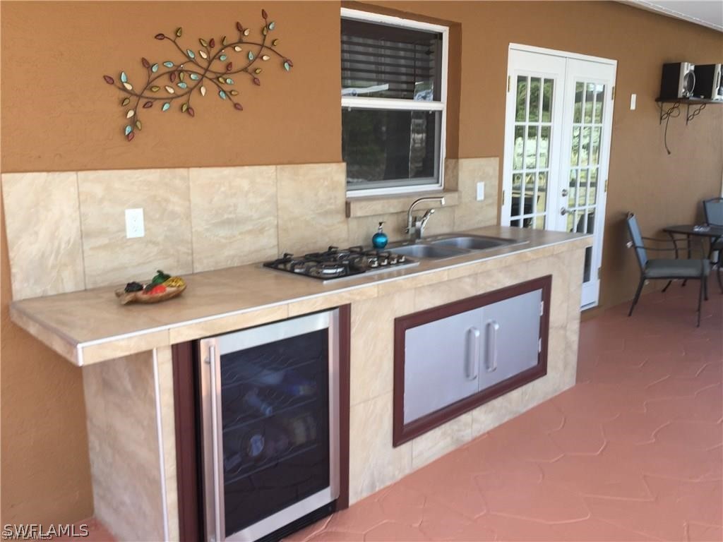 239 Rue Labonne Road Fort Myers, FL 33913 - Photo 9 of 22 a kitchen with a stove a sink a refrigerator and a window