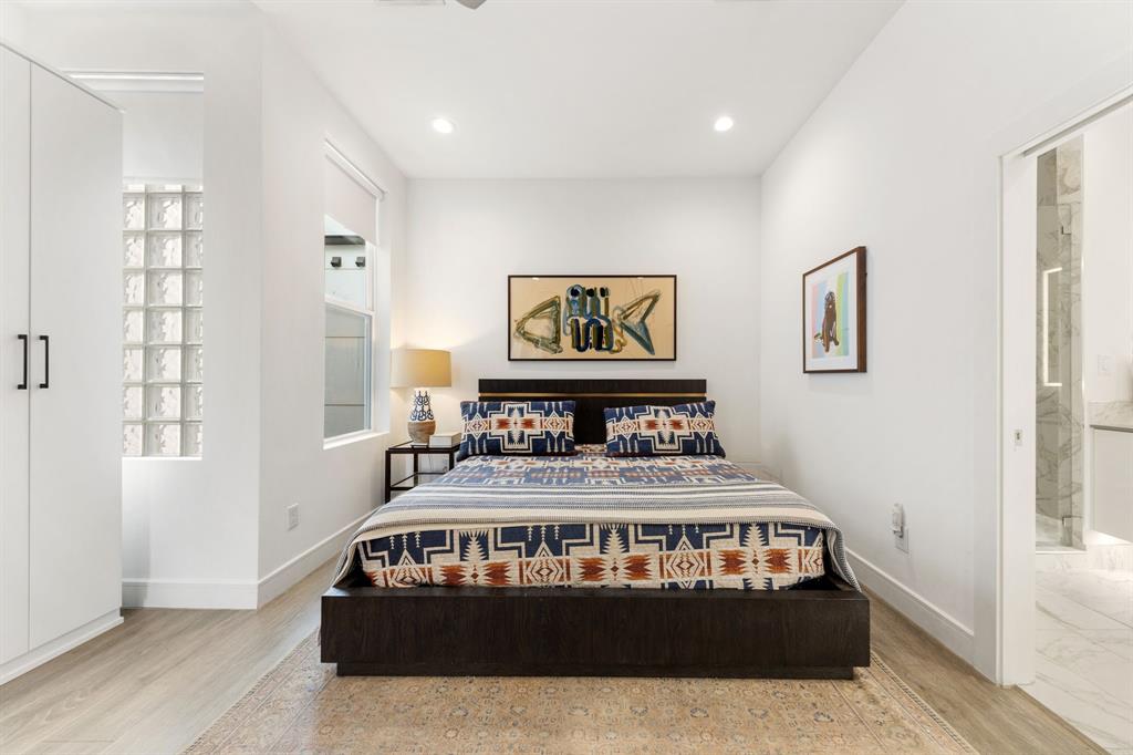 3880 Munger Avenue, Unit 2 Dallas, TX 75204 - Photo 20 of 29 a bedroom with a bed a painting on the wall and a window