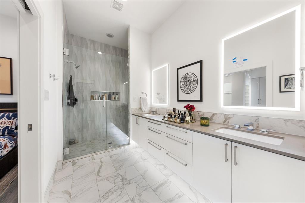 3880 Munger Avenue, Unit 2 Dallas, TX 75204 - Photo 23 of 29 a bathroom with double vanity sinks a shower a mirror and a shower