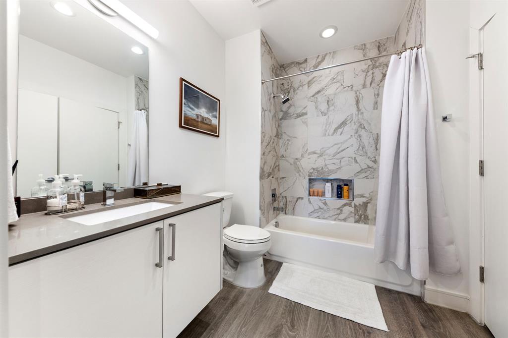 3880 Munger Avenue, Unit 2 Dallas, TX 75204 - Photo 26 of 29 a bathroom with a sink a toilet a mirror a vanity and shower