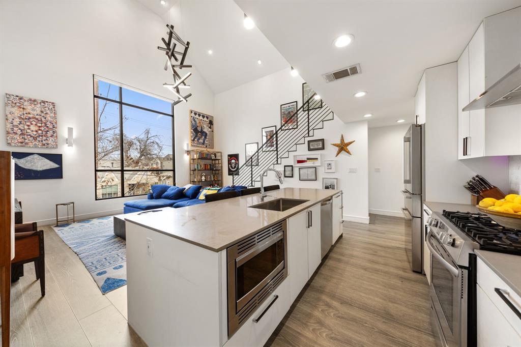 3880 Munger Avenue, Unit 2 Dallas, TX 75204 - Photo 7 of 29 a large kitchen with stainless steel appliances kitchen island a large counter tops a stove a sink and a refrigerator