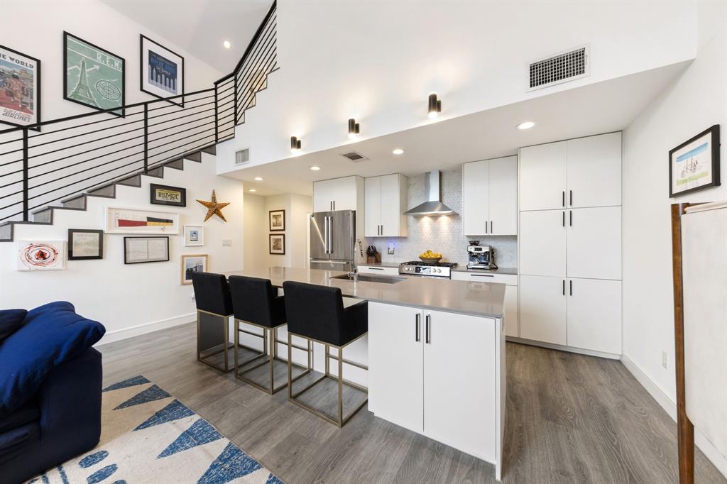 3880 Munger Avenue, Unit 2 Dallas, TX 75204 - Photo 9 of 29 a kitchen with stainless steel appliances kitchen island granite countertop a refrigerator a stove a sink dishwasher and white cabinets with wooden floor