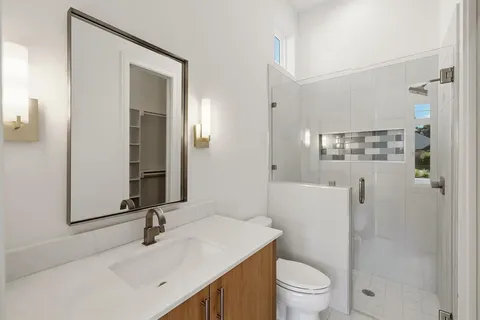 a bathroom with a sink a toilet and shower