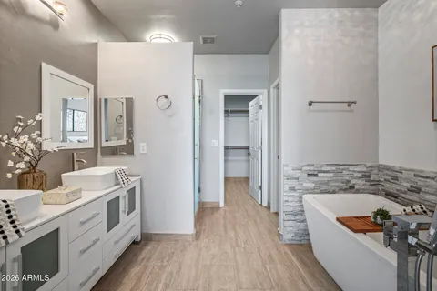 a bathroom with a tub sink and mirror