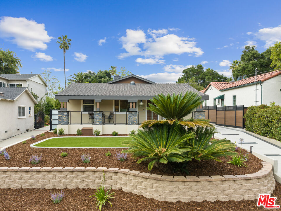 a front view of a house with a garden and yard