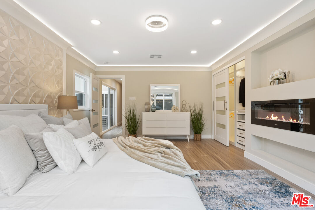 393 Allendale Road Pasadena, CA 91106 - Photo 50 of 75 a spacious bedroom with a large bed a fireplace and a couch