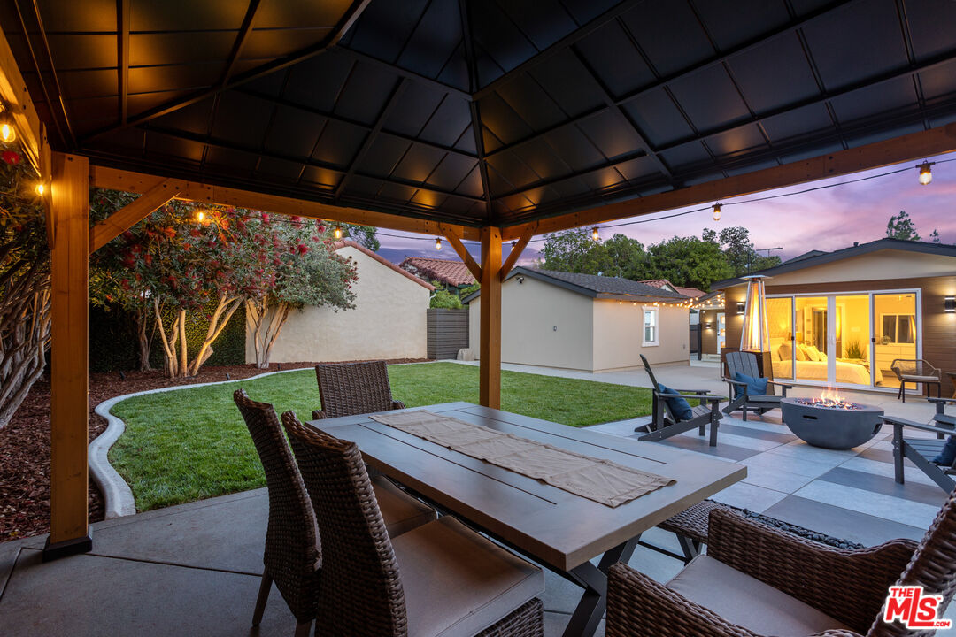 393 Allendale Road Pasadena, CA 91106 - Photo 65 of 75 a view of a patio with table and chairs under an umbrella with a small yard