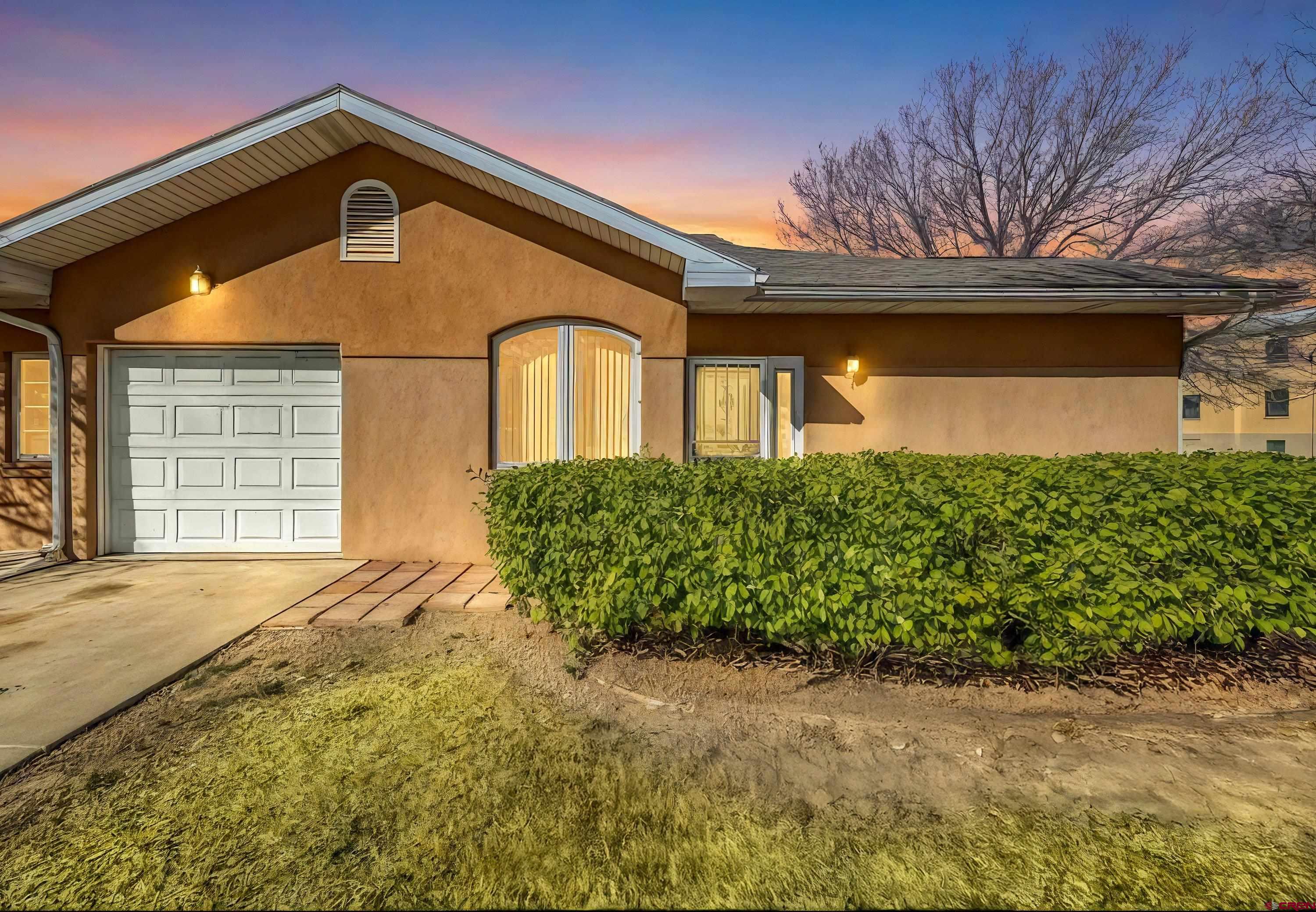 401 Grand Avenue, Unit B Delta, CO 81416 - Photo 2 of 14 a front view of a house with a yard and garage