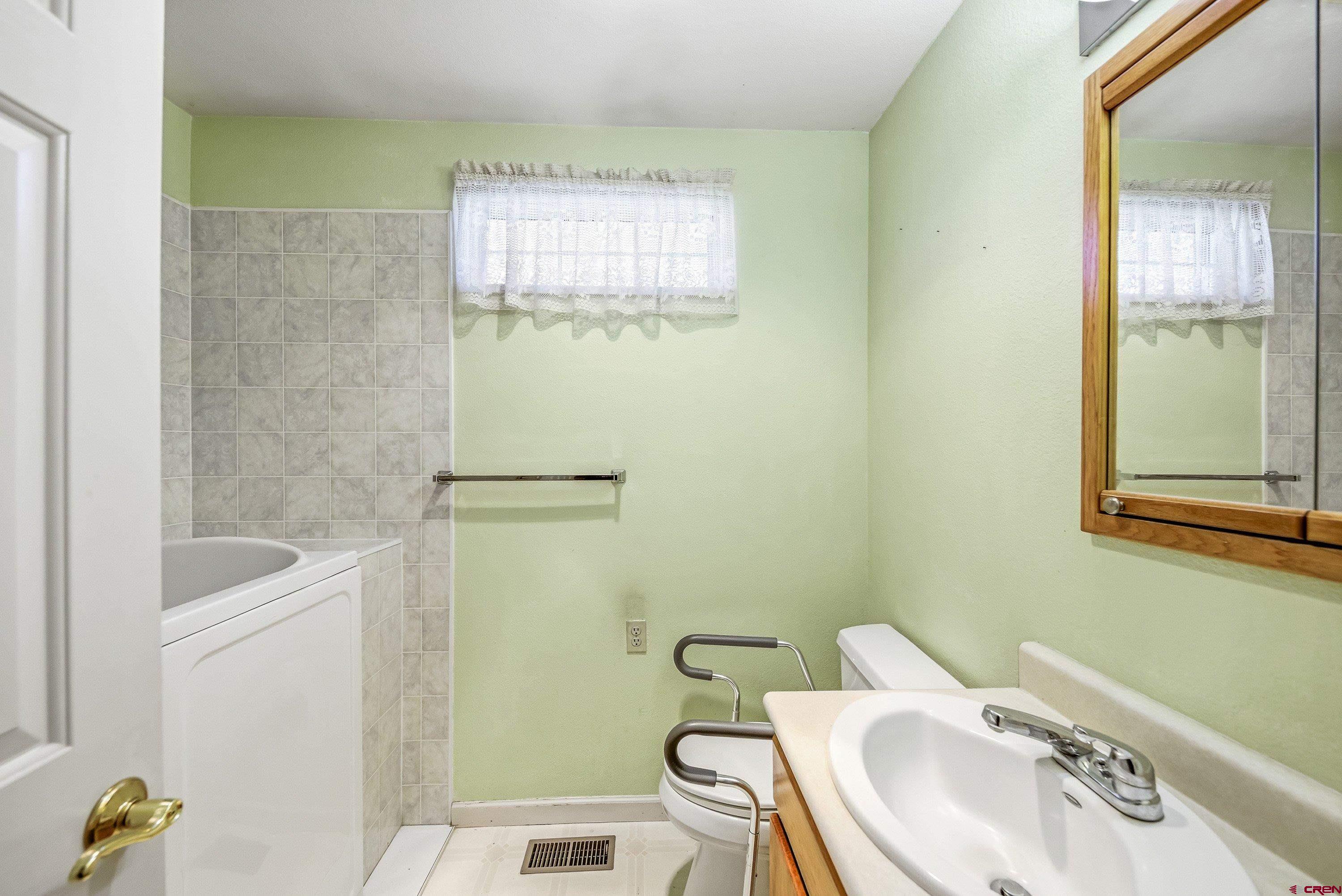 401 Grand Avenue, Unit B Delta, CO 81416 - Photo 9 of 14 a bathroom with a sink a toilet and shower