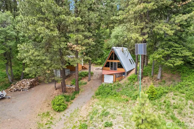 an aerial view of a house with swimming pool and trees