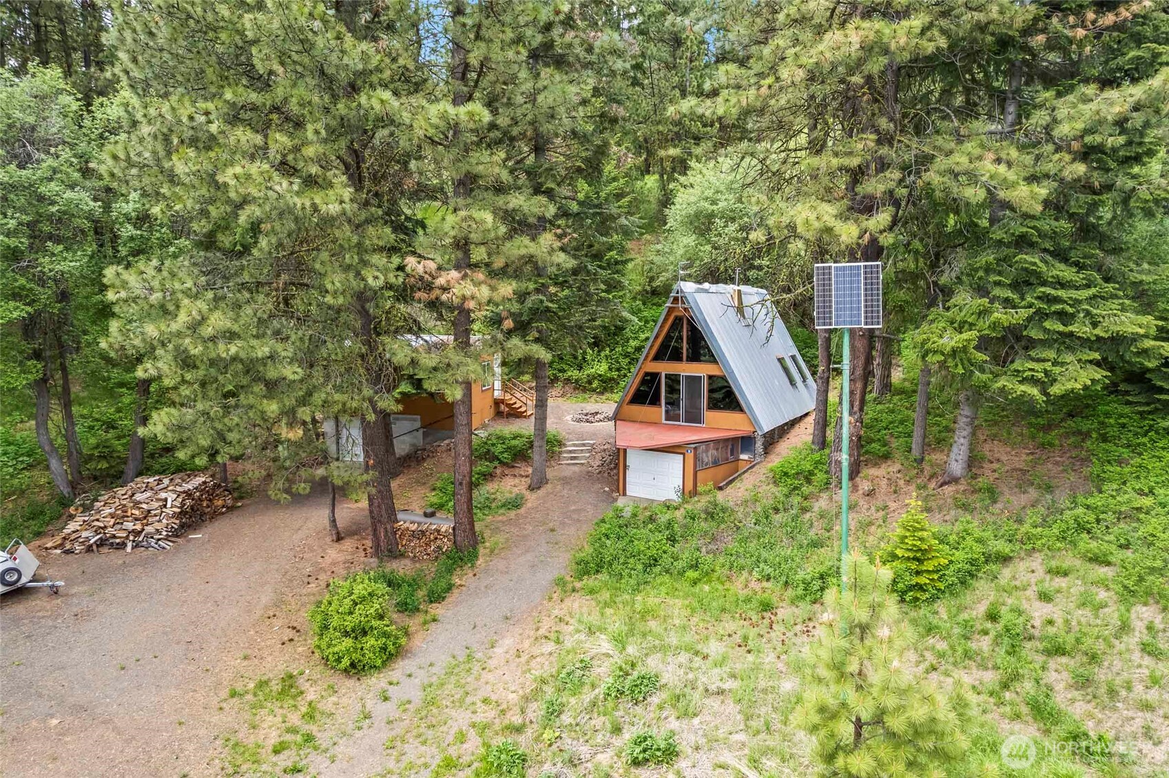 an aerial view of a house with swimming pool and trees