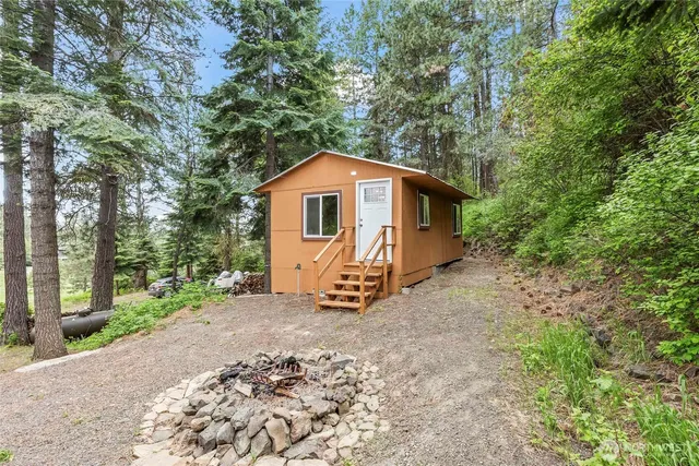 a view of a small house with a tree in the background