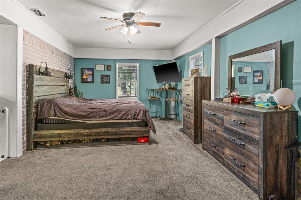 2376 County Road 4119 Daingerfield, TX 75638 - Photo 11 of 40 a bedroom with a bed a dresser and flat screen tv