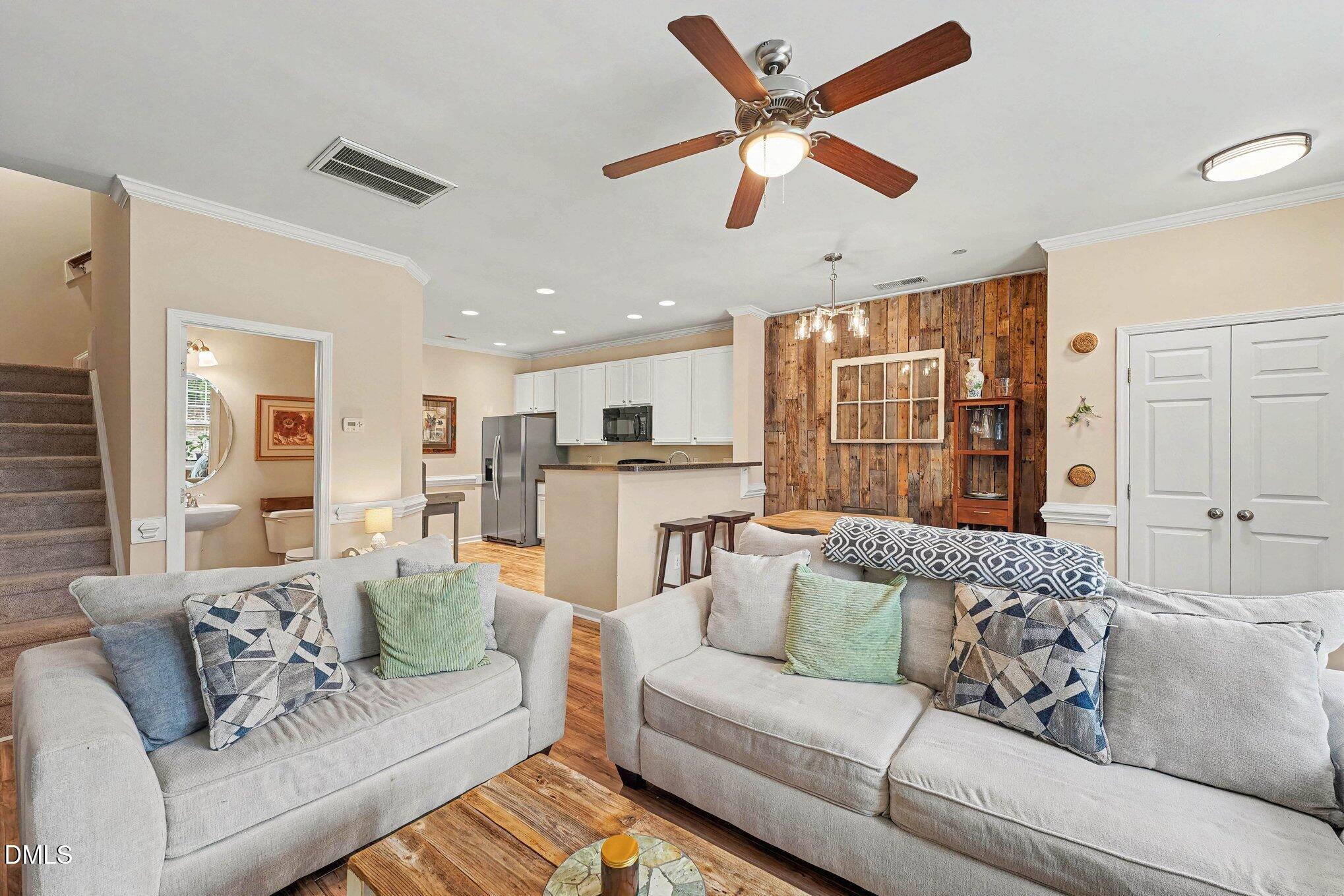 1130 Renewal Place, Unit 106 Raleigh, NC 27603 - Photo 6 of 34 a living room with furniture kitchen area and a ceiling fan