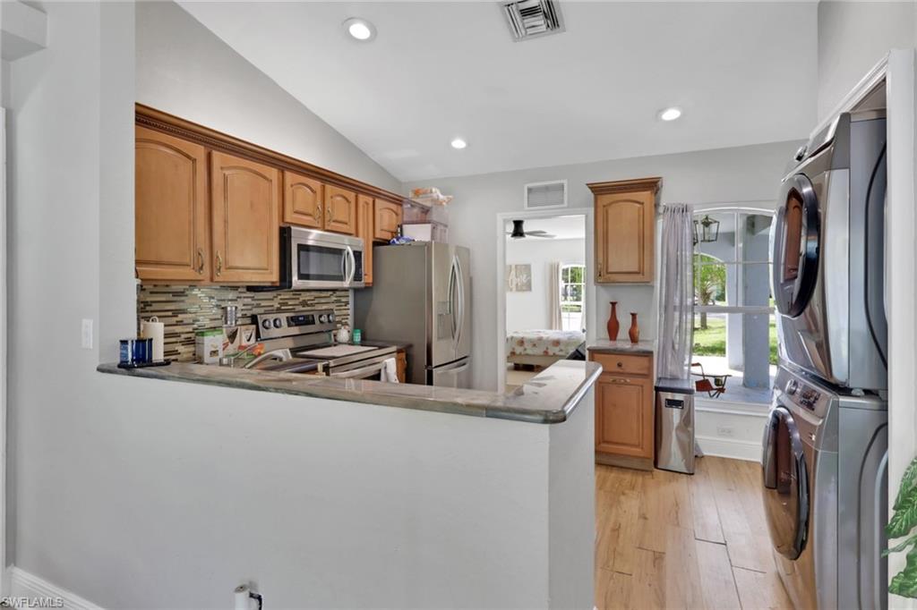 3341 2nd Avenue Southeast Naples, FL 34117 - Photo 11 of 43 a kitchen with stainless steel appliances a refrigerator sink and cabinets