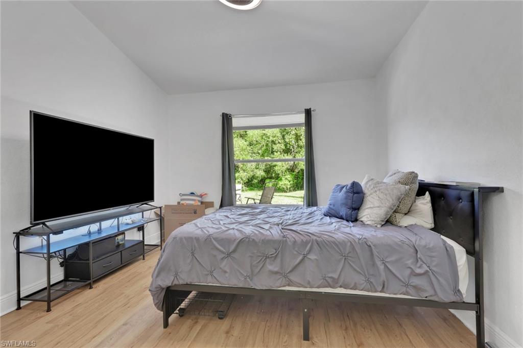 3341 2nd Avenue Southeast Naples, FL 34117 - Photo 16 of 43 a bedroom with a bed and a flat screen tv