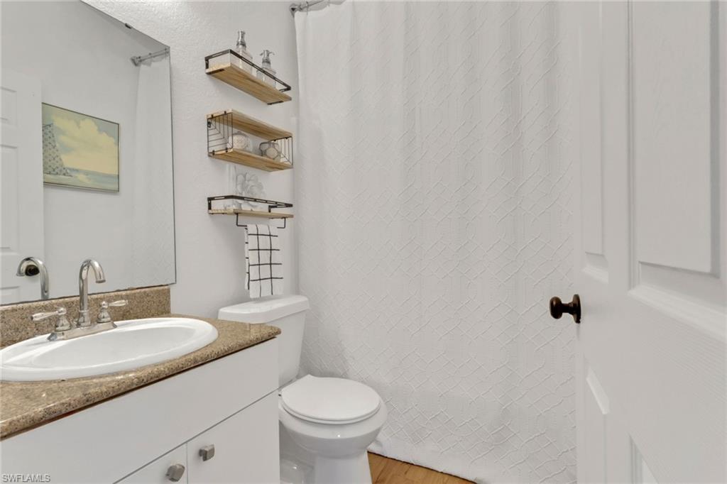 3341 2nd Avenue Southeast Naples, FL 34117 - Photo 23 of 43 a bathroom with a granite countertop sink toilet and a mirror