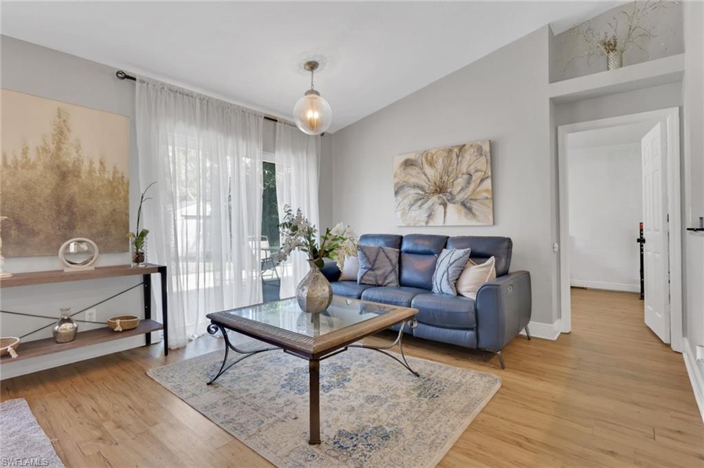 3341 2nd Avenue Southeast Naples, FL 34117 - Photo 7 of 43 a living room with furniture and a wooden floor