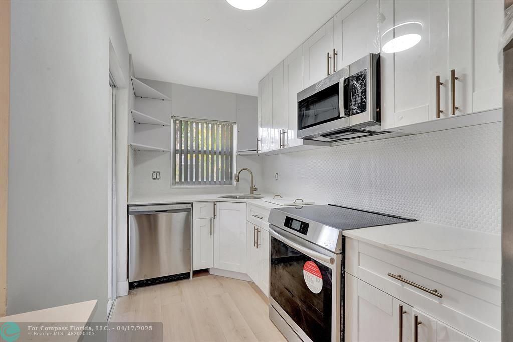 161 Northeast 10th Avenue, Unit 14A Hallandale Beach, FL 33009 - Photo 19 of 45 a kitchen with stainless steel appliances a stove microwave and sink