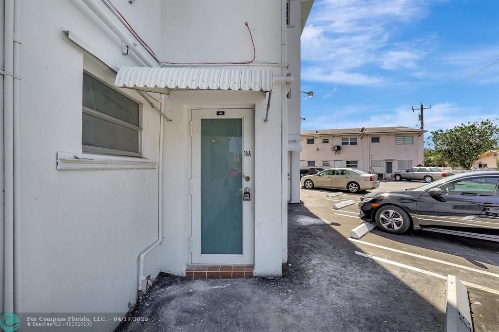 161 Northeast 10th Avenue, Unit 14A Hallandale Beach, FL 33009 - Photo 28 of 45 a view of a car park in front of a house