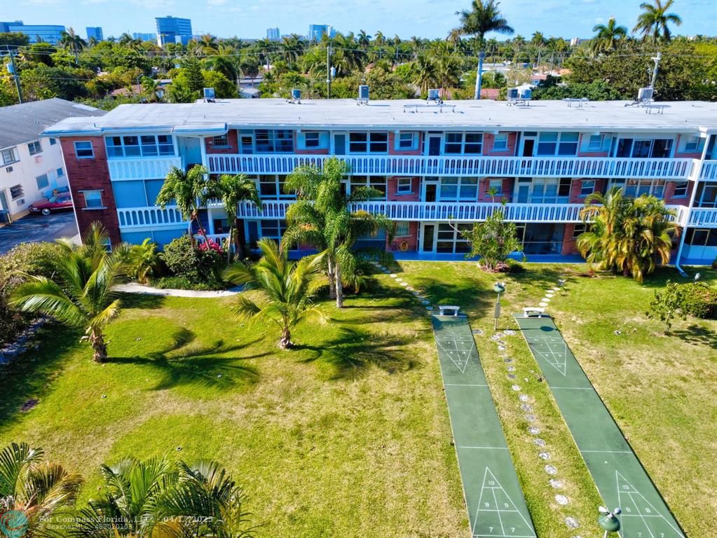 161 Northeast 10th Avenue, Unit 14A Hallandale Beach, FL 33009 - Photo 44 of 45 a view of a swimming pool with potted plants and large trees