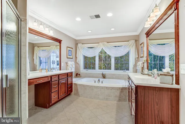 a spacious bathroom with a tub sink and mirror