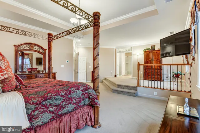 a bedroom with a bed a flat screen tv and dresser