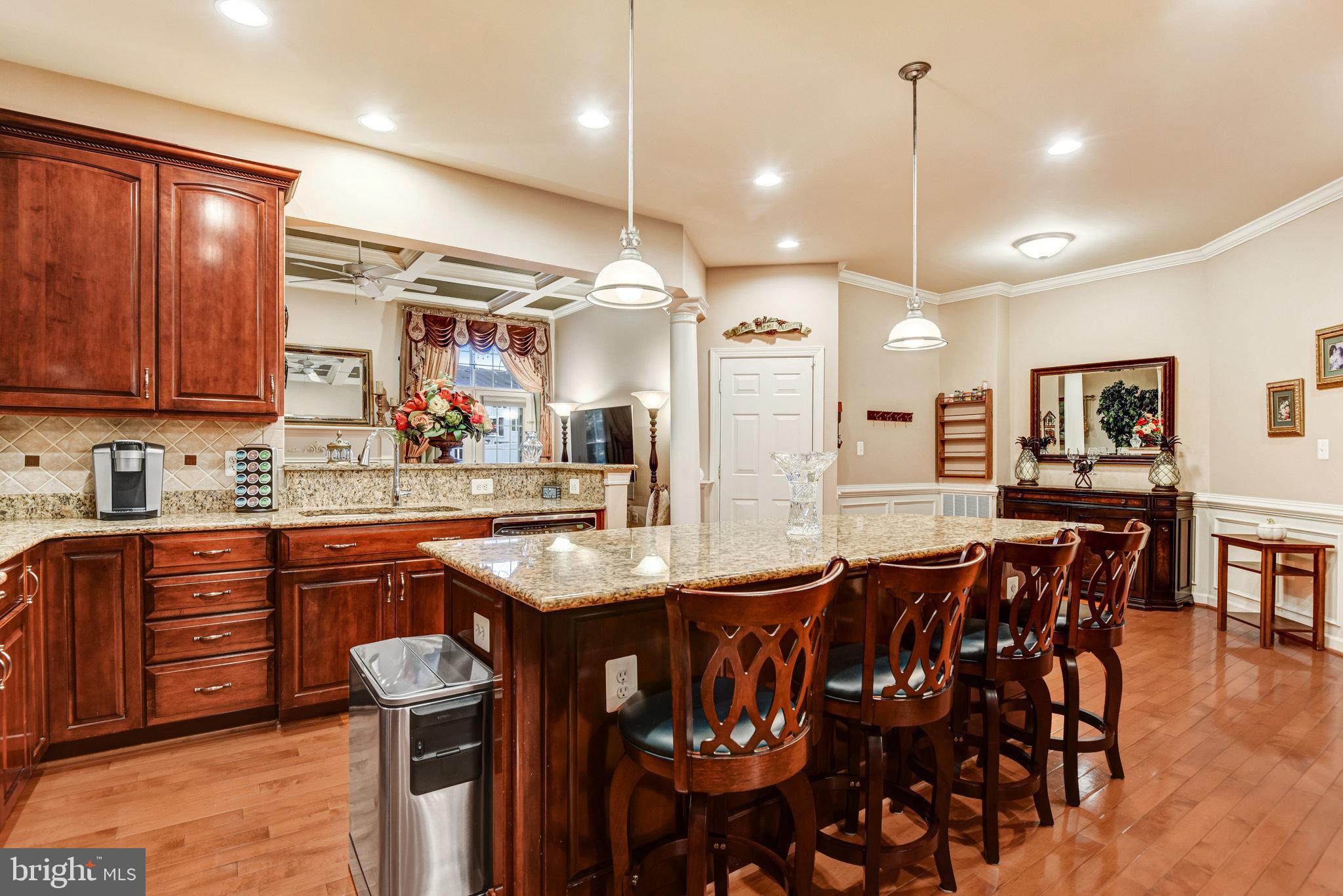 24958 Brookbark Terrace Chantilly, VA 20152 - Photo 8 of 26 a kitchen with stainless steel appliances granite countertop a sink a stove a dining table and chairs