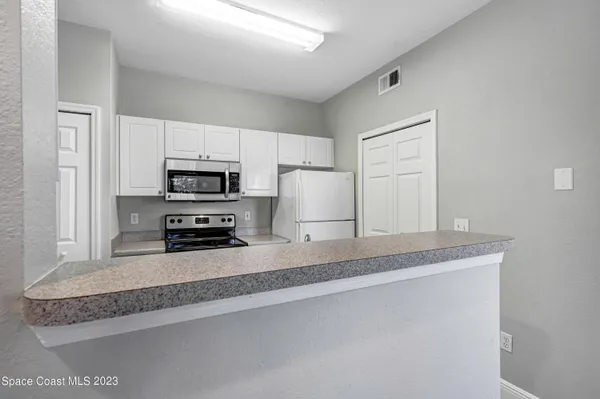 a kitchen with stainless steel appliances granite countertop a sink a stove a microwave and a refrigerator