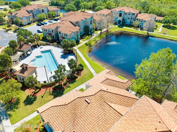 a view of a swimming pool with a lawn chairs under an umbrella