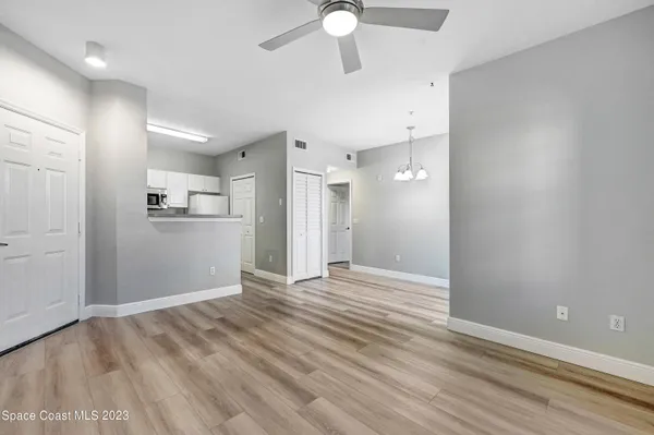 wooden floor in an empty room with a kitchen